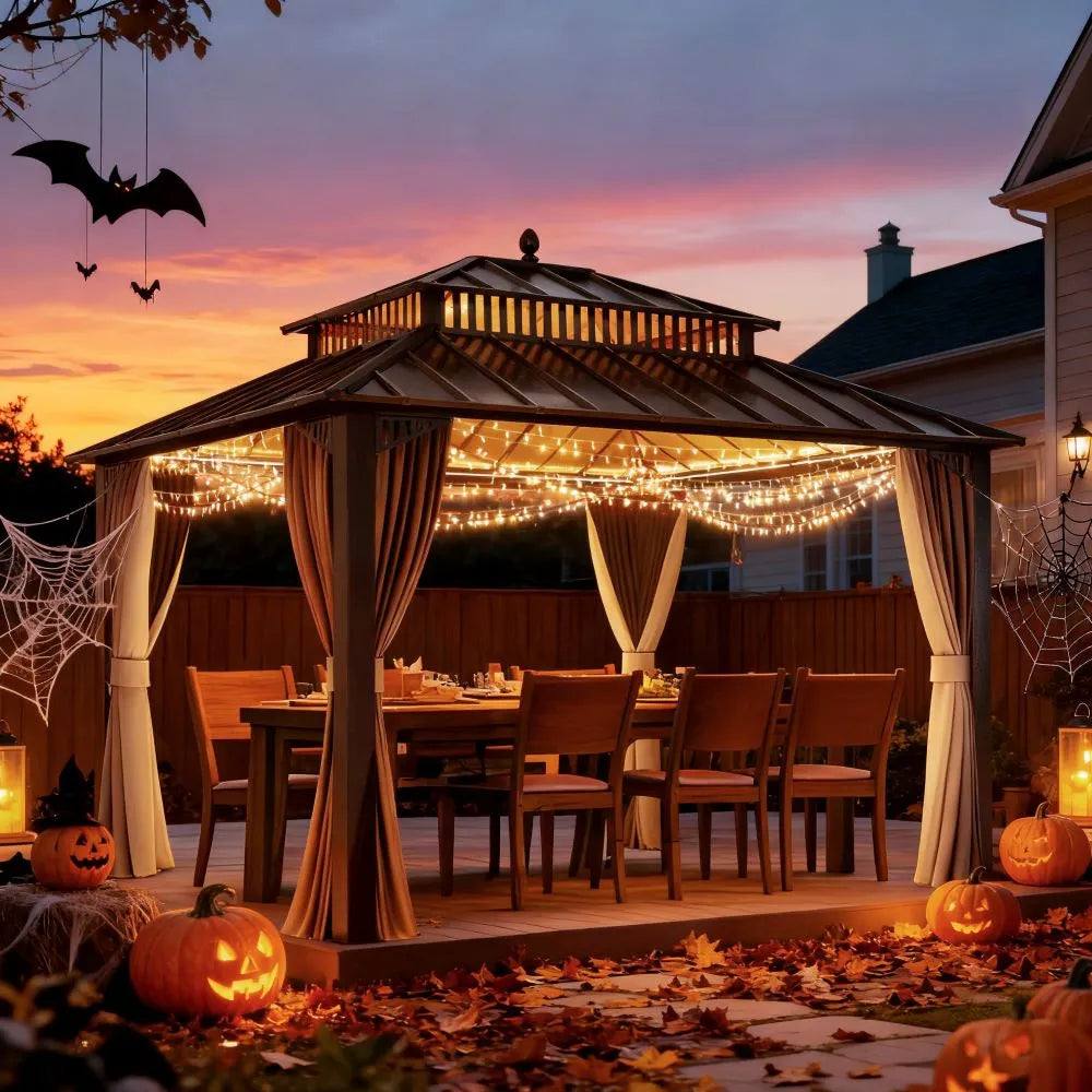 Halloween-themed outdoor gazebo with string lights, pumpkins, and bats against a sunset sky.