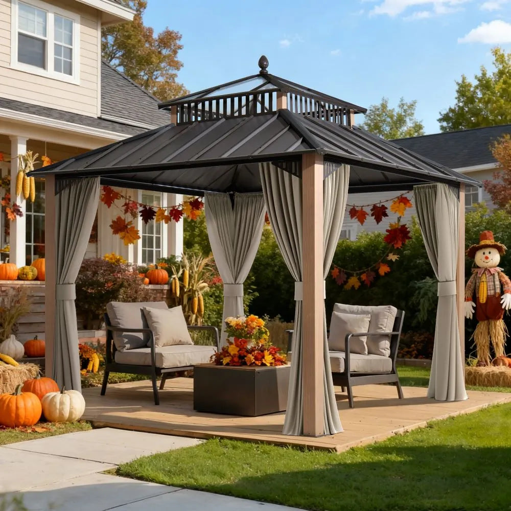 Outdoor gazebo with curtains on a patio, decorated for fall with pumpkins and a scarecrow.