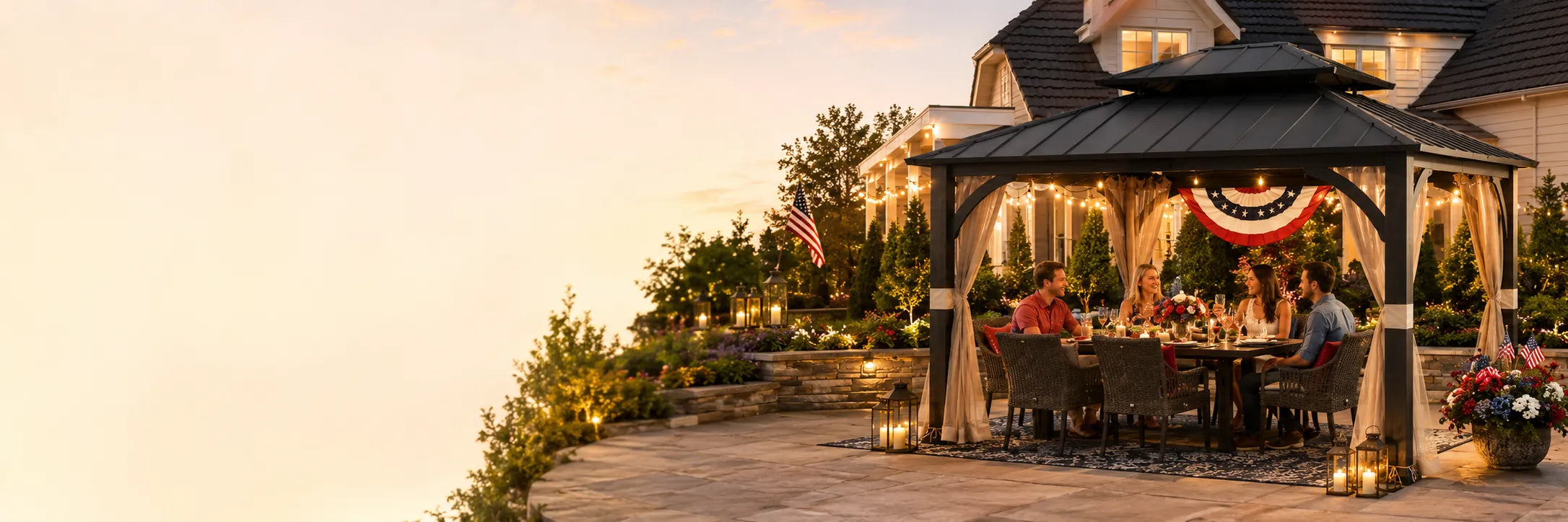 People sitting at a table under a gazebo with a sunset or sunrise in the background.