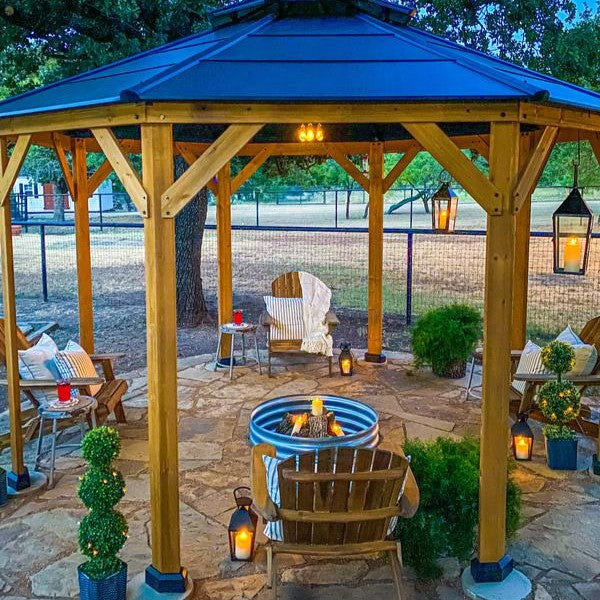Outdoor gazebo with fire pit and seating area in a backyard setting
