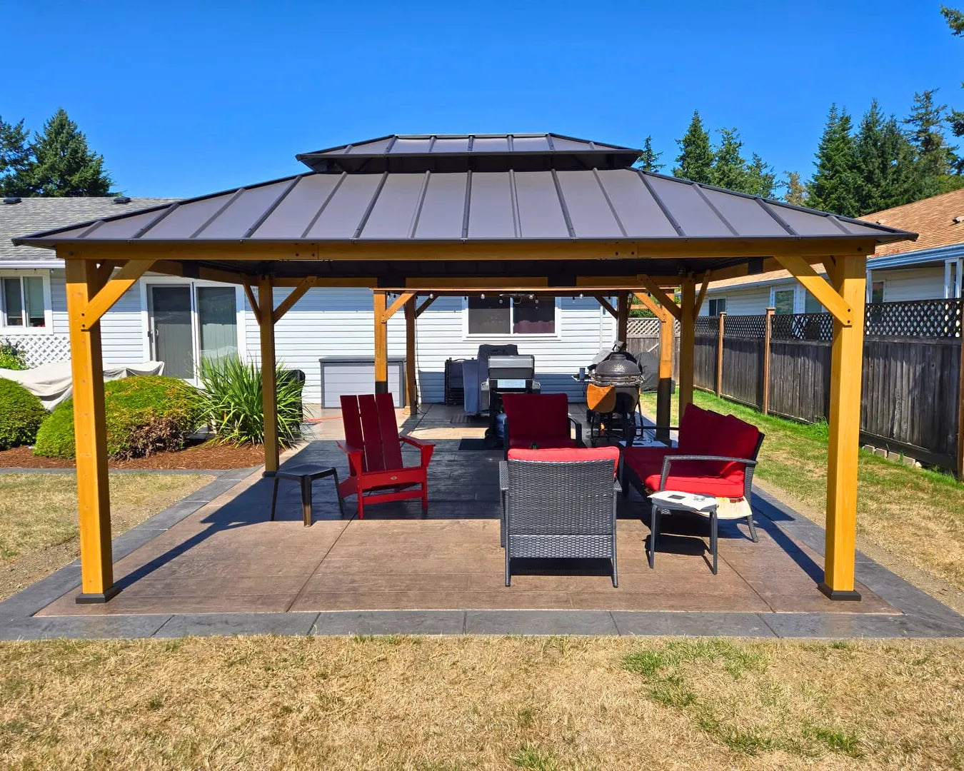 Patio with wooden gazebo, outdoor furniture, and clear blue sky